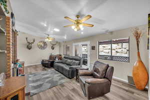 Living room featuring a textured ceiling, light hardwood / wood-style floors, and ceiling fan