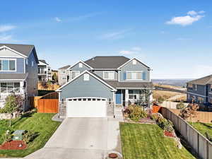 View of front of house featuring a front lawn and a garage