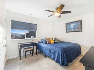 Carpeted bedroom featuring ceiling fan