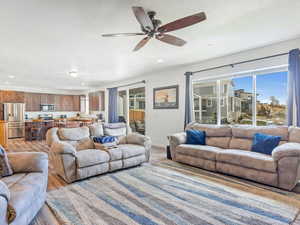 Living room featuring a textured ceiling, light hardwood / wood-style flooring, and ceiling fan