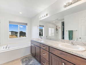 Bathroom with tile patterned floors, vanity, and separate shower and tub