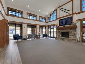 Unfurnished living room with a fireplace, a high ceiling, and hardwood / wood-style flooring