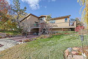 Back of house with a lawn, a patio area, and a deck