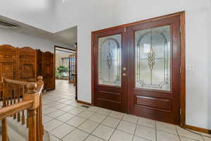 Tiled entrance foyer featuring french doors and plenty of natural light