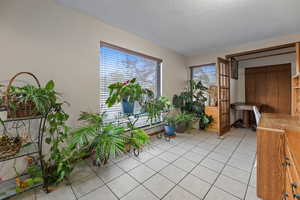 Sitting room featuring light tile patterned flooring and a textured ceiling