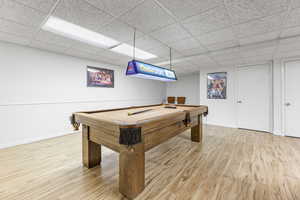 Rec room featuring hardwood / wood-style flooring, a drop ceiling, and pool table