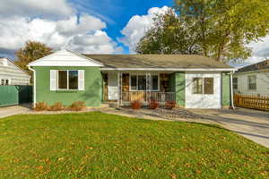 View of front facade with covered porch and a front lawn