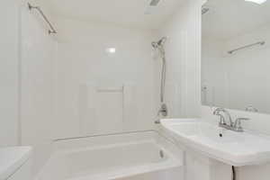 Full bathroom featuring sink, shower / bath combination, and toilet