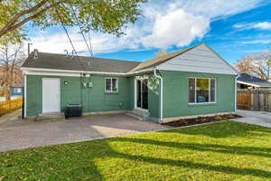 Rear view of property featuring a yard, a patio, and central air condition unit