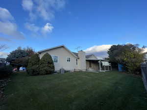 Back of property with a lawn and central air condition unit