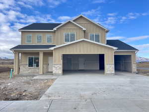 View of front facade with a mountain view and 4 car garage