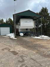 Exterior space featuring a carport, an outdoor structure, and a garage