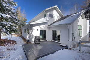 Snow covered house with a wooden deck