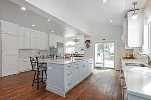 Kitchen featuring white cabinets, pendant lighting, a kitchen island, and stainless steel oven