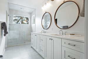 Bathroom with tile patterned flooring, vanity, and walk in shower