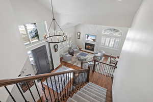 Stairway with a large fireplace, high vaulted ceiling, and plenty of natural light