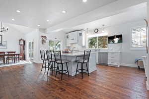 Kitchen featuring a breakfast bar, dishwasher, and a healthy amount of sunlight