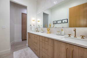 Bathroom with vanity and tasteful backsplash