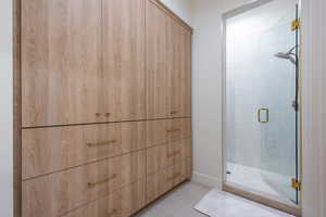 Bathroom with tile patterned flooring and a shower with door