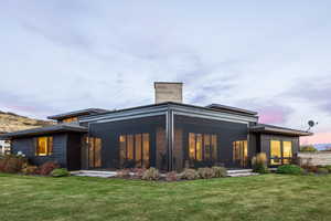 Back house at dusk with a lawn