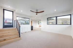 Spare room featuring light carpet and ceiling fan