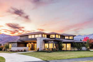 Prairie-style home with a lawn and a mountain view