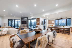 Dining room with a large fireplace and light wood-type flooring