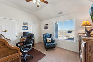 Carpeted office featuring ceiling fan and lofted ceiling