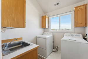 Laundry area with cabinets, sink, and washing machine and dryer