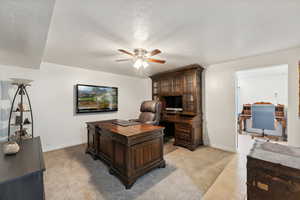 Home office featuring light tile patterned floors, a textured ceiling, and ceiling fan