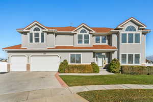 View of front of home with a front yard and a garage