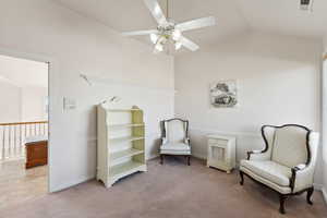 Sitting room featuring light carpet, ceiling fan, and vaulted ceiling