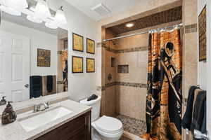 Bathroom featuring vanity, toilet, and walk in shower