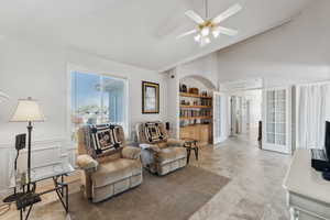 Living room with french doors, built in features, ceiling fan, and lofted ceiling