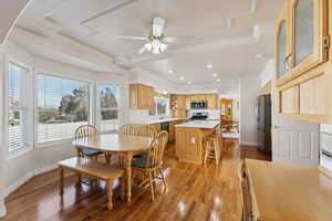 Dining area with ceiling fan, sink, light hardwood / wood-style floors, and ornamental molding