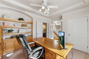 Office area featuring ceiling fan, light carpet, and a tray ceiling