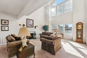 Carpeted living room with a towering ceiling