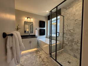 Bathroom featuring shower with separate bathtub and vanity.  Image is of furnished model home - finishes will differ.