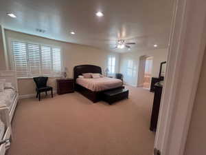 Carpeted bedroom featuring ceiling fan