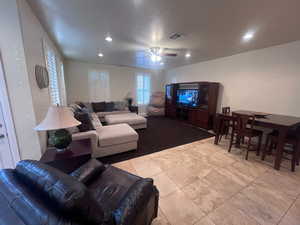 Living room featuring ceiling fan and light tile patterned floors