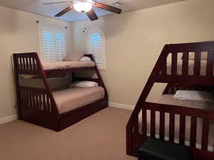 Bedroom with ceiling fan and light colored carpet