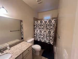 Full bathroom featuring tile patterned flooring, shower / tub combo, vanity, and toilet