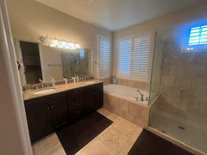 Bathroom featuring tile patterned floors, vanity, and plus walk in shower