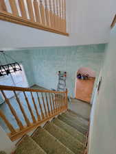 Stairway with carpet, a towering ceiling, and a notable chandelier