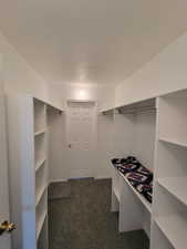 Walk in closet with dark colored carpet