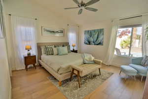 Bedroom featuring light hardwood / wood-style flooring, ceiling fan, and lofted ceiling