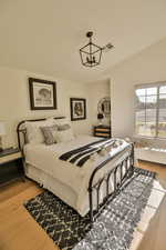 Bedroom featuring light wood-type flooring and an inviting chandelier