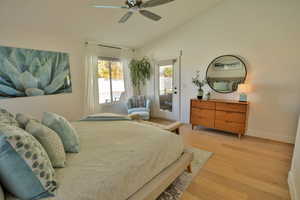 Bedroom featuring ceiling fan, light hardwood / wood-style floors, access to outside, and vaulted ceiling