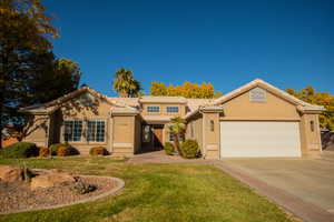 View of front of house with a garage and a front lawn