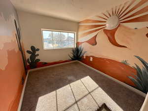 Empty room with carpet and a textured ceiling